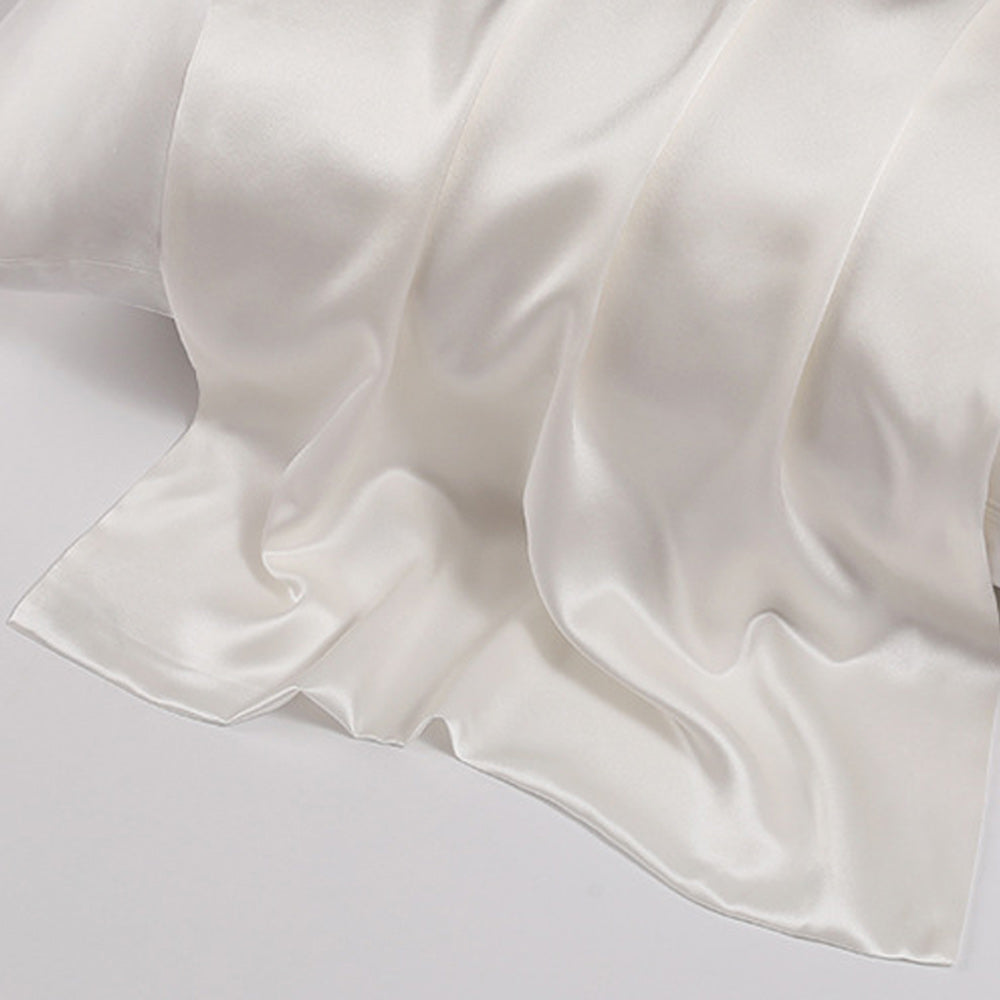 Close-up shot of ohmysilk White 22 momme mulberry silk pillowcase with a secure envelope closure, showing natural silk texture and soft wrinkles.